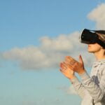 Panotour Pro: Como implementar un spot a un recorrido virtual Es una mujer con gafas de realidad virtual y un cielo de fondo