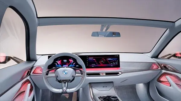 Interior del vehículo BMW i4 mostrando su pantalla de infotenimiento y acabados de lujo