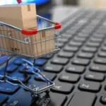 E-commerce, La Salvación para Microempresas Textiles en Chapinero Carrito de compras lleno, encima de un portatil